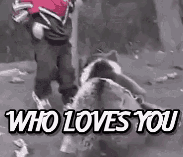 a person standing next to a bear with the words who loves you written on it