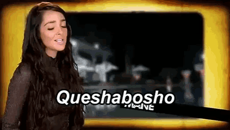 a woman is standing in front of a screen with queshabosho written on it