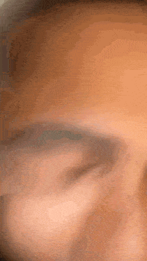 a close up of a person 's face with a blurry background .