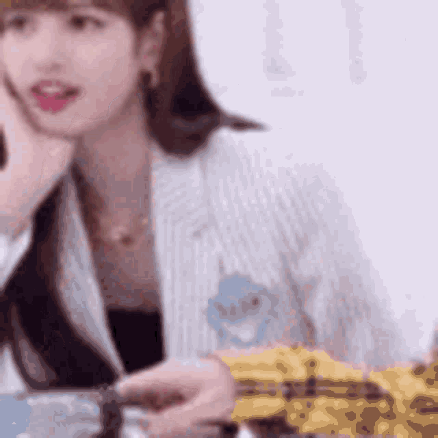 a woman is sitting at a table talking on a phone .