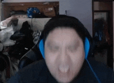a man wearing headphones is sitting in front of a computer screen .