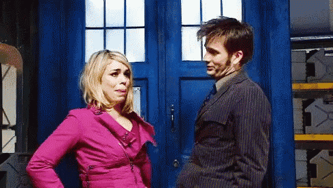 a man and woman are standing in front of a blue door .