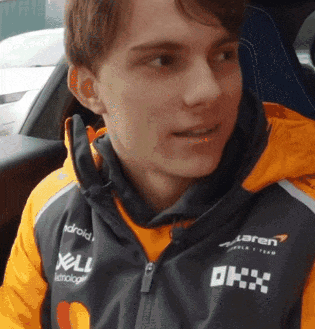 a young man wearing a jacket that says okx on it