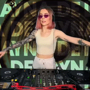 a woman wearing sunglasses and headphones is standing in front of a dj mixer with her arms outstretched .