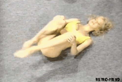 a woman in a yellow bikini is laying on a carpet .