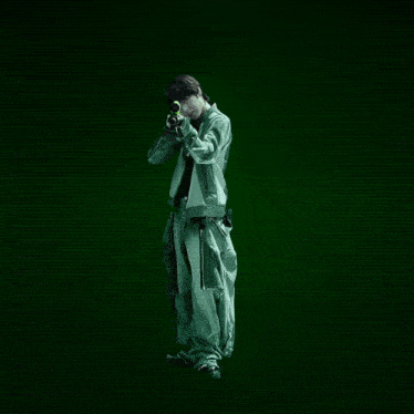 a man in a green jacket is holding a sniper rifle in front of a green background