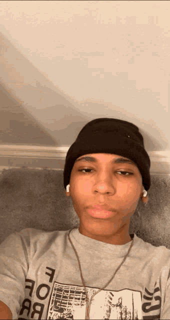 a young man wearing a beanie and a t-shirt that says " fore " on it