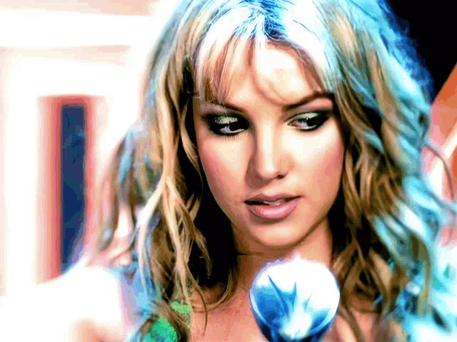 a woman with blue hair holds a microphone in her hand