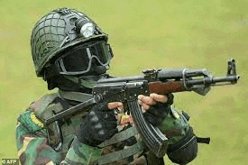 a soldier is wearing a helmet and goggles and holding a gun .