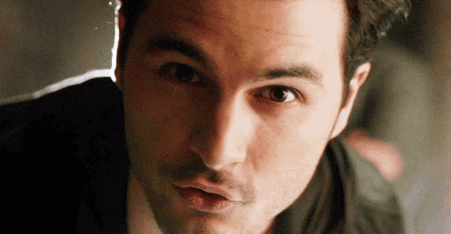 a close up of a man 's face with a dark background