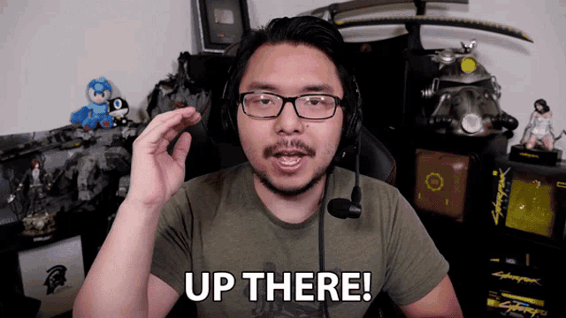 a man wearing headphones says up there