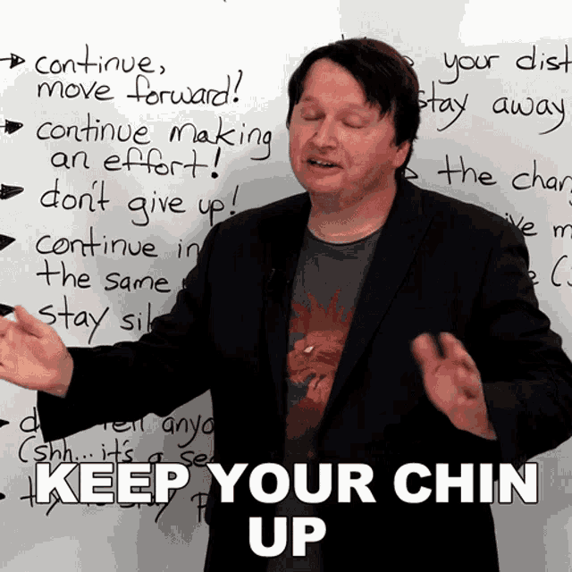 a man stands in front of a white board with the words " keep your chin up " written on it