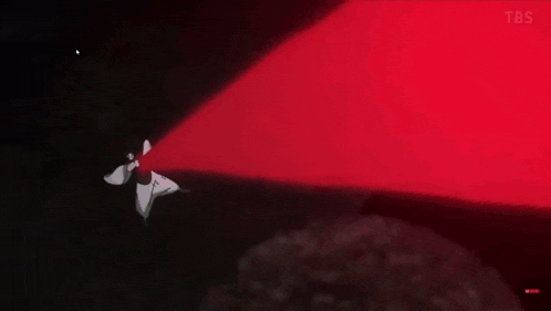 a red light is shining on a person in the dark .