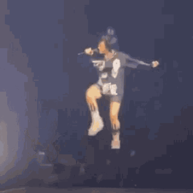 a blurry picture of a person standing on a stage in the dark .
