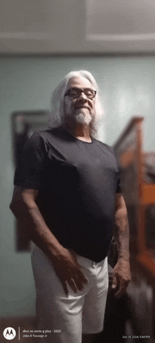 a man in a black shirt and white shorts stands in a room