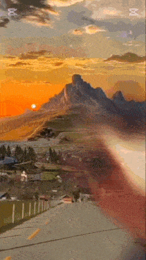 a painting of a road with mountains in the background at sunset