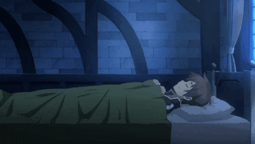 a person laying on a bed with a green blanket and a white pillow