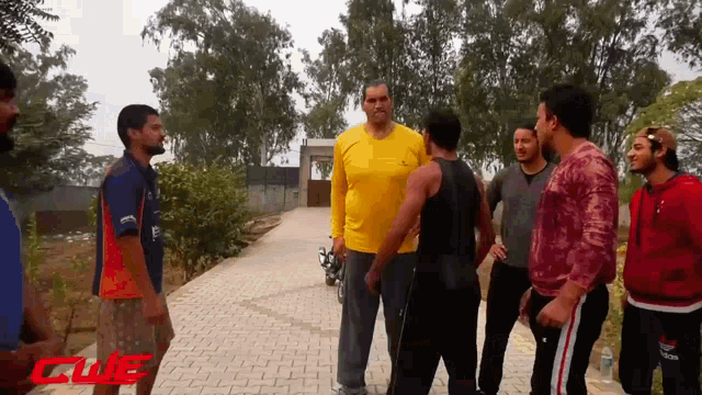 a group of men are standing on a sidewalk with clue written on the bottom