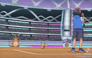a boy is standing next to a pikachu and a charizard in a pokemon stadium .
