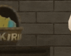a person is standing in front of a brick wall next to a basket that says ' kiri ' on it .