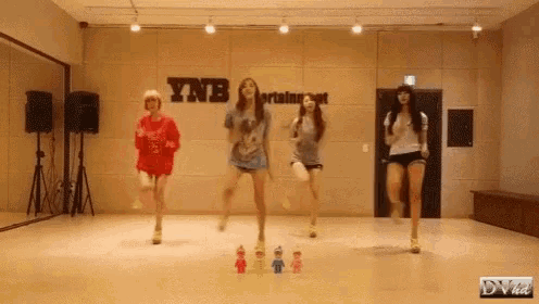 a group of girls are dancing in a dance studio with a sign that says ynb