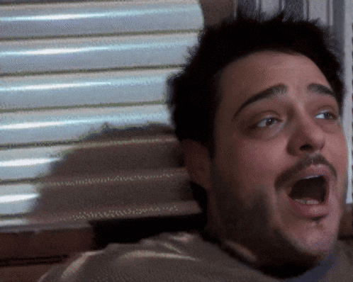 a close up of a man 's face with a surprised look on his face
