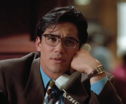 a man with glasses is talking on a phone