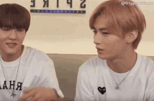 two young men are sitting next to each other and one of them is wearing a t-shirt that says " ана "