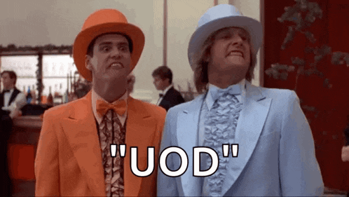 two men in suits and hats are standing next to each other in a room and saying uod .