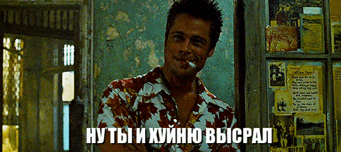 a man in a hawaiian shirt is smoking a cigarette in front of a wall with posters on it in a room