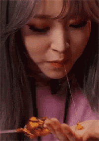 a woman is eating a piece of pizza with a fork and spoon .