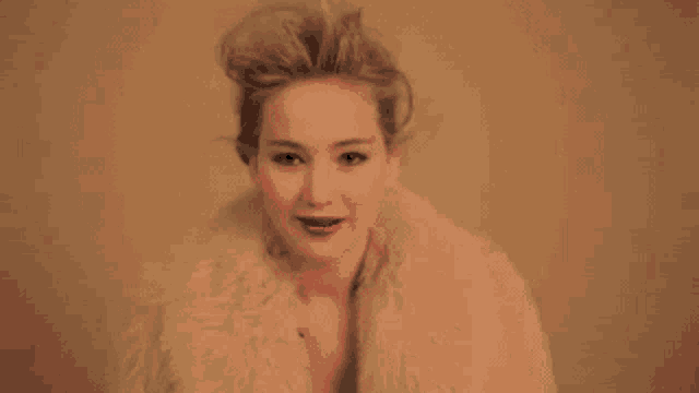 a woman wearing a fur coat and red lipstick is smiling and looking at the camera .