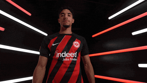 a man wearing a black and red shirt that says indeed on it