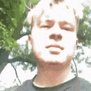 a young man wearing headphones and a black shirt is looking at the camera .