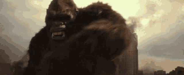 a giant gorilla is standing in front of a destroyed building in a city .
