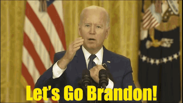 a man in a suit and tie is giving a speech with the words let 's go brandon on the bottom