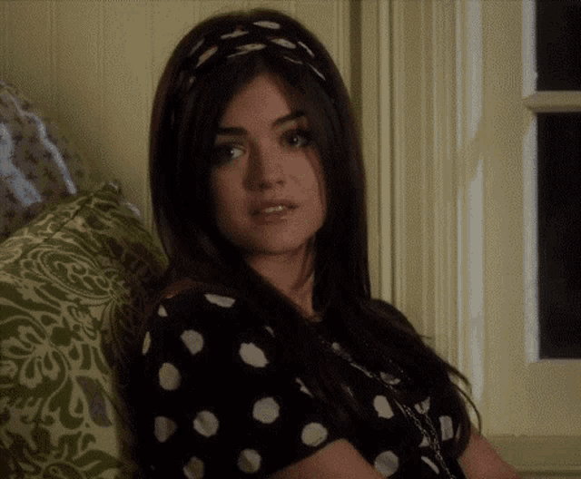 a woman wearing a headband and a polka dot shirt