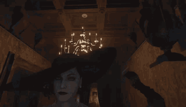 a woman in a hat is standing in a dark room with a chandelier hanging from the ceiling
