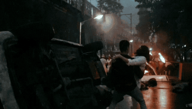 a man is carrying a woman on his back in a crowded area .