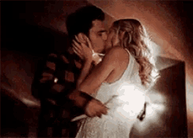a man and a woman are kissing in a room .
