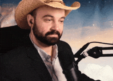 a man with a beard wearing a cowboy hat and earbuds