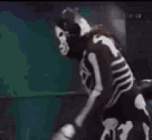 a skeleton is fighting a wrestler in a ring .