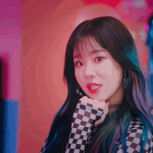 a girl with blue hair and red lips is wearing a checkered shirt