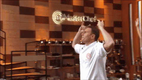 a man stands in front of a master chef sign