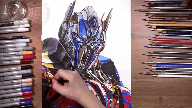 a drawing of optimus prime is surrounded by colored pencils and markers