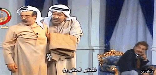 two men are standing next to each other with arabic writing on the bottom