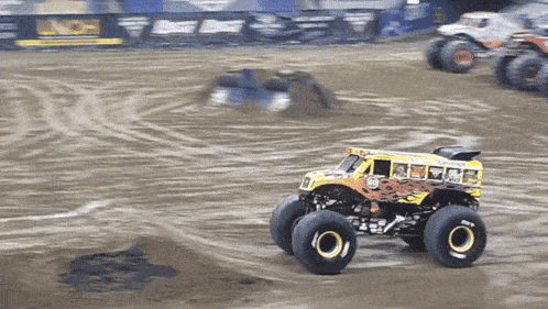 a monster truck that looks like a school bus is on a dirt track