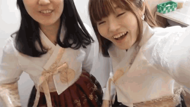 two girls are standing next to each other and one has a red skirt on