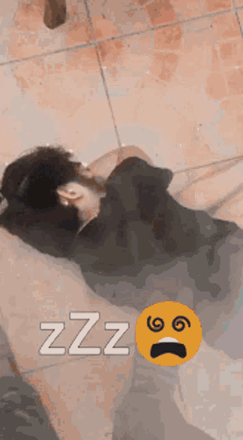 a person laying on a tiled floor with zzz written on the bottom