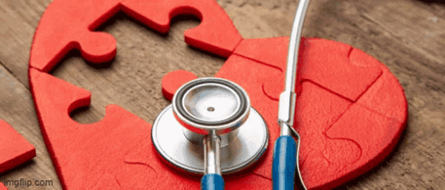 a stethoscope is sitting on top of a red heart made of puzzle pieces